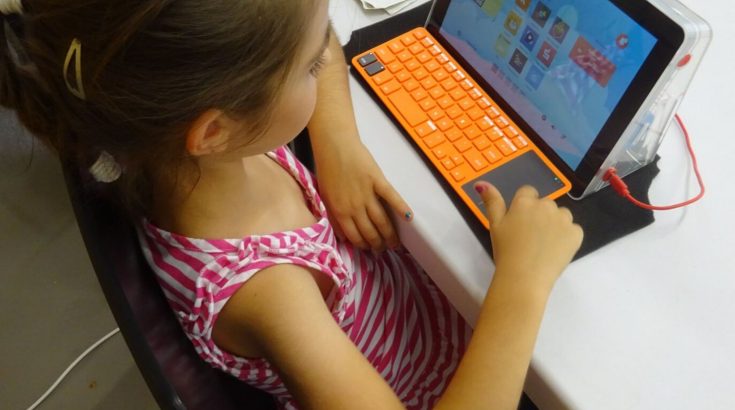 Dziewczynka siedząca przy laptopie.