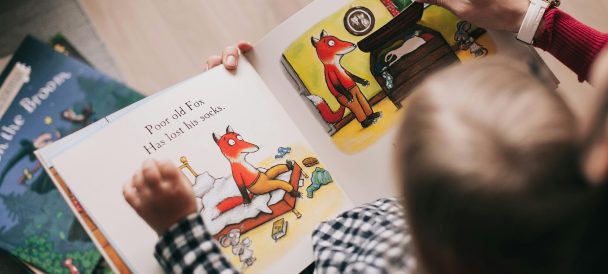 dziecko czytające z rodzicem książkę po angielsku