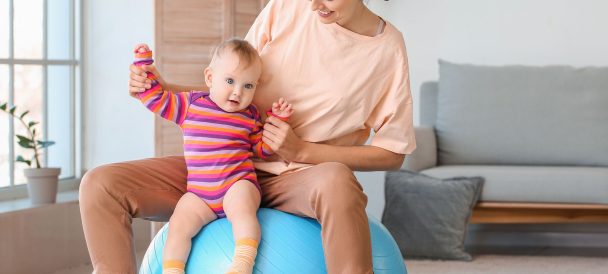 Mama na piłce do pilatesu z dzieckiem