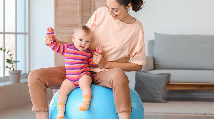 Mama na piłce do pilatesu z dzieckiem