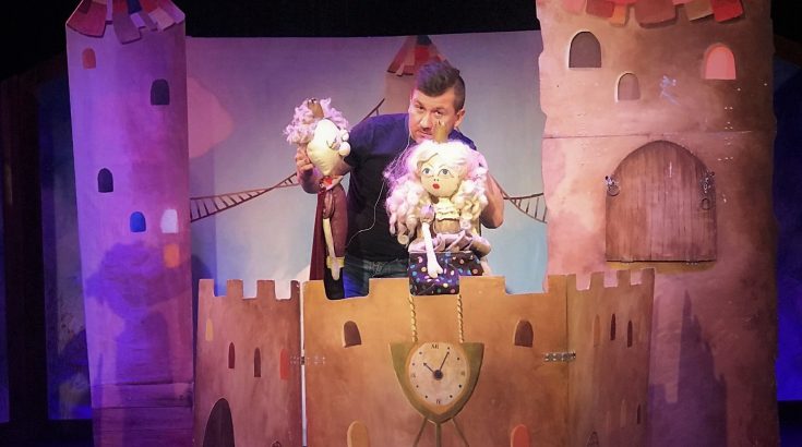 Mężczyzna trzymający dwie kukiełki