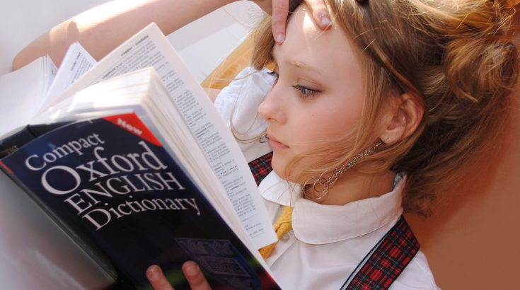 Młoda dziewczyna czytająca słownik angielskiego